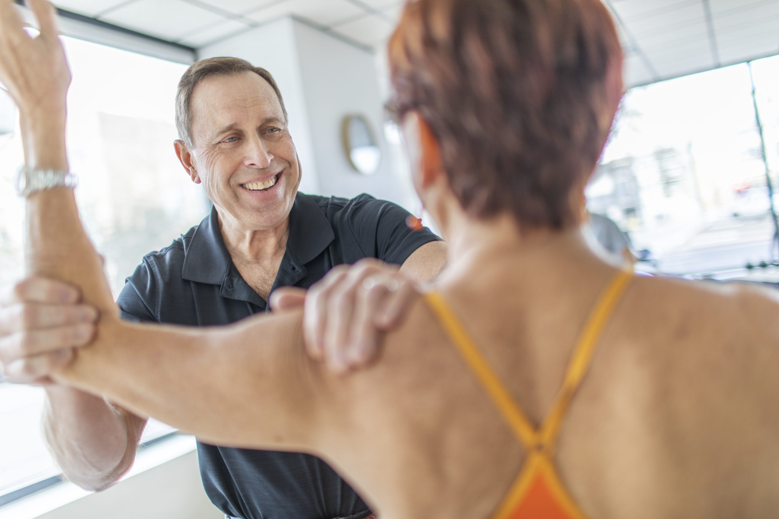 Physical therapist, Tony Marek, working with a patient. They are focusing on arms.